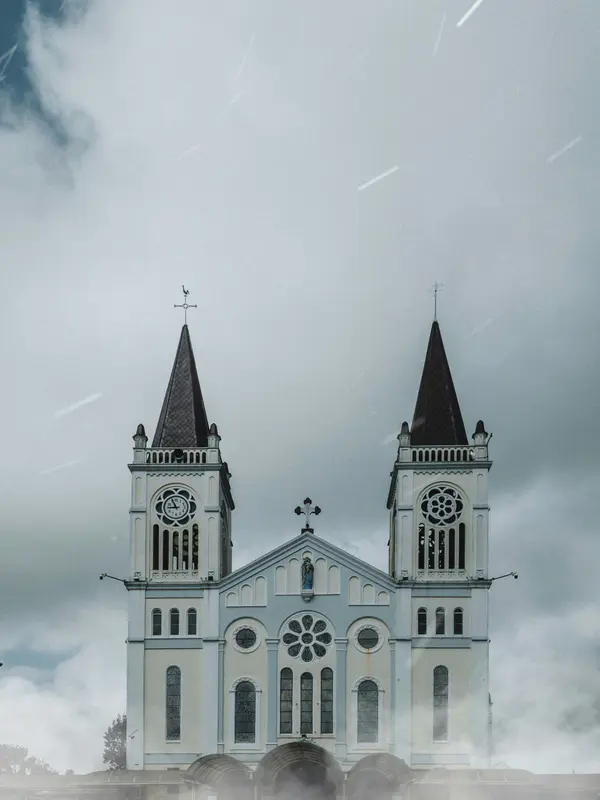 The twin spires of Baguio Cathedral against a misty sky