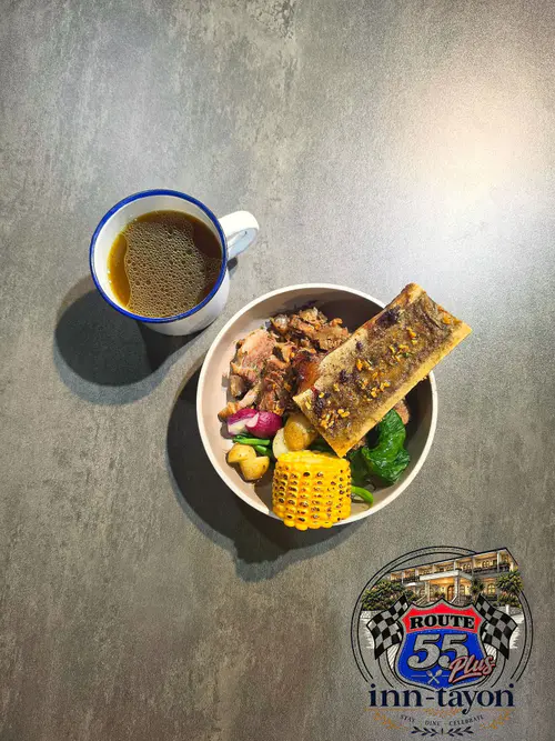 Hearty soup with grilled corn, bone marrow and a cup of broth, seen from above